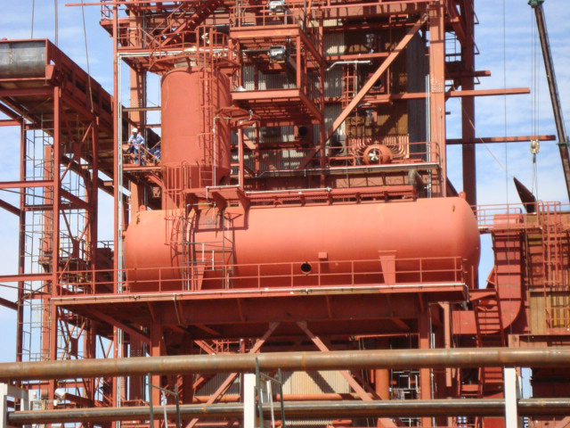 Detalhe de desaerador vertical em unidade industrial, mostrando reservatório pressurizado e conexões responsáveis pela remoção de oxigênio da água.