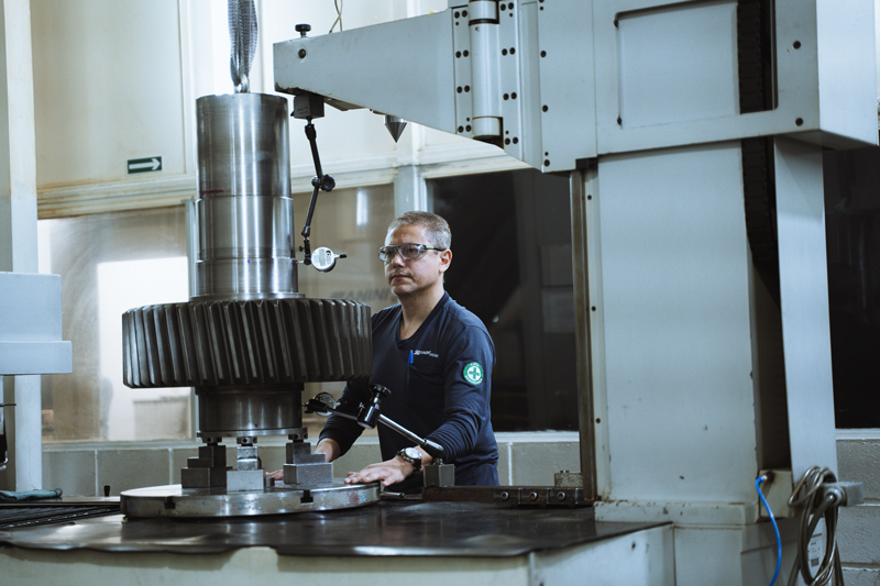 Engenheiro da Zanini Renk trabalhando em engrenagem industrial.