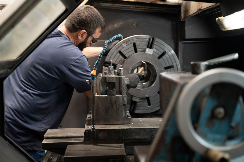 Profissional da Zanini Renk realizando manuten&ccedil;&atilde;o em equipamento rotativo.