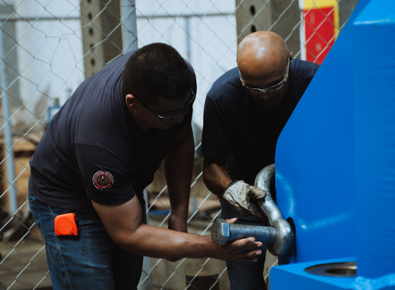 Equipe técnica executando intervenção em máquina industrial, reforçando a importância de suporte especializado e atendimento rápido em operações contínuas.