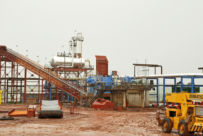 Sistema de desaeração de água de alimentação de caldeira em área industrial, com tanque horizontal, torre de pulverização e tubulações de vapor.